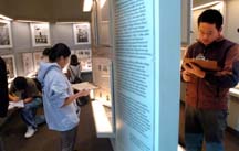 Students taking notes in the Portraits of Survival Exhibition