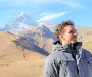 Sergey Salushchev headshot in front of brown mountains