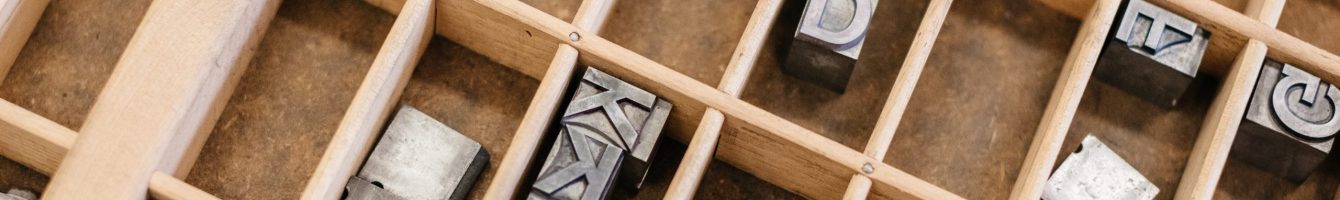 Wooden compartments full of metal letters.