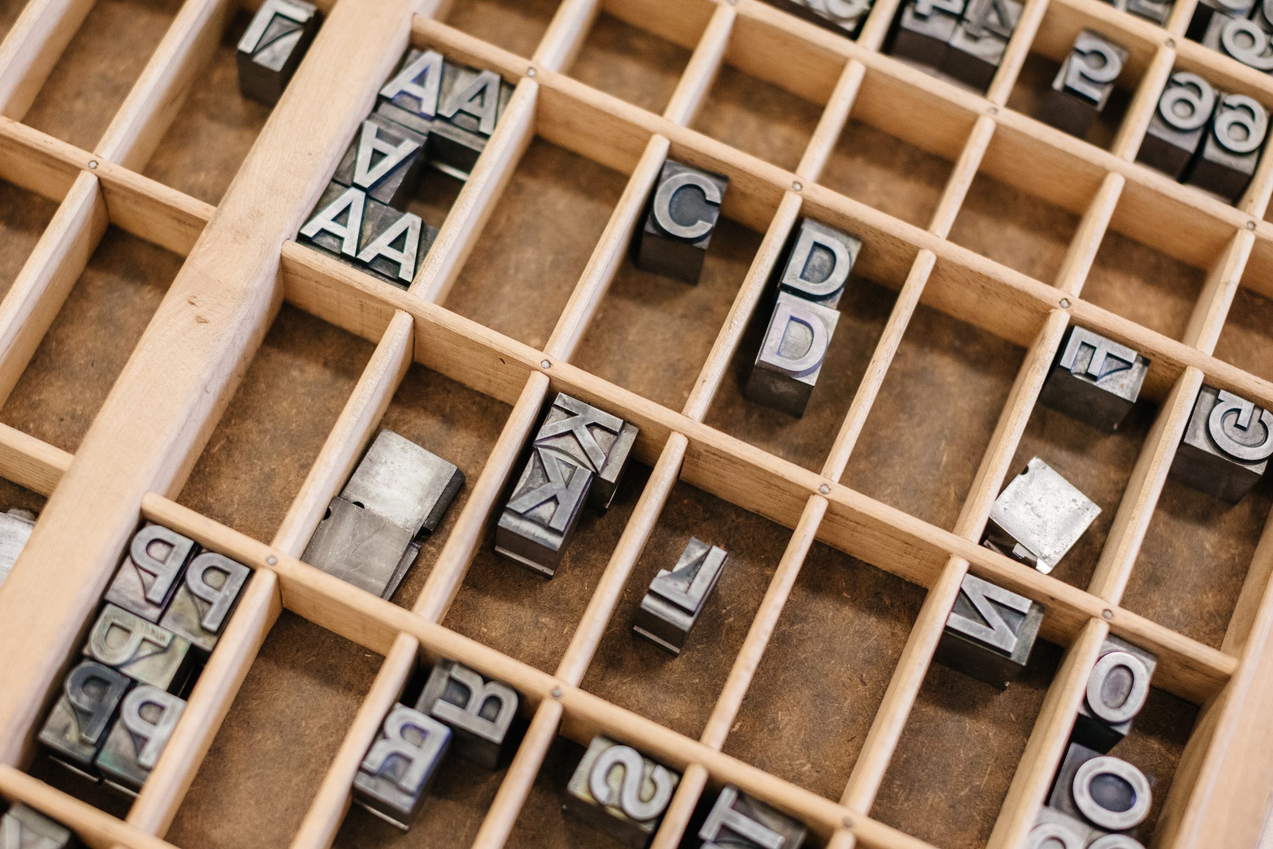 Wooden compartments full of metal letters.