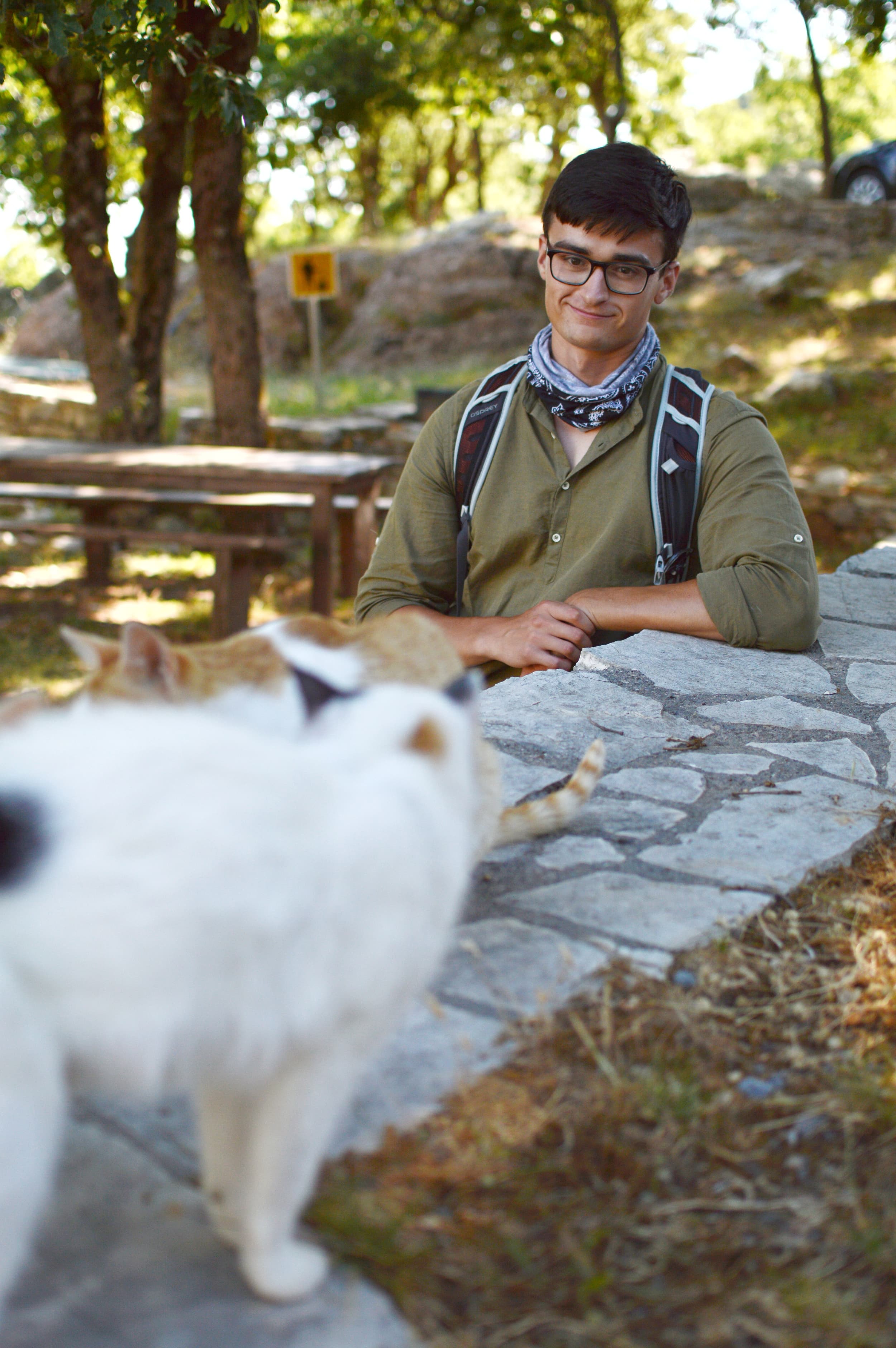Evan Axel Andersson in outdoor picnic setting with two cats
