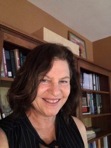 Erika Rappaport headshot in front of a bookshelf