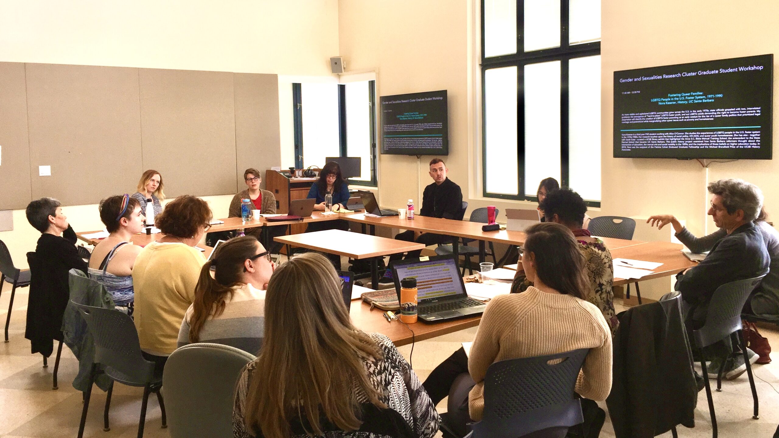 People gathered around a table for the Gender and Sexualities Research Cluster Graduate Student Workshop