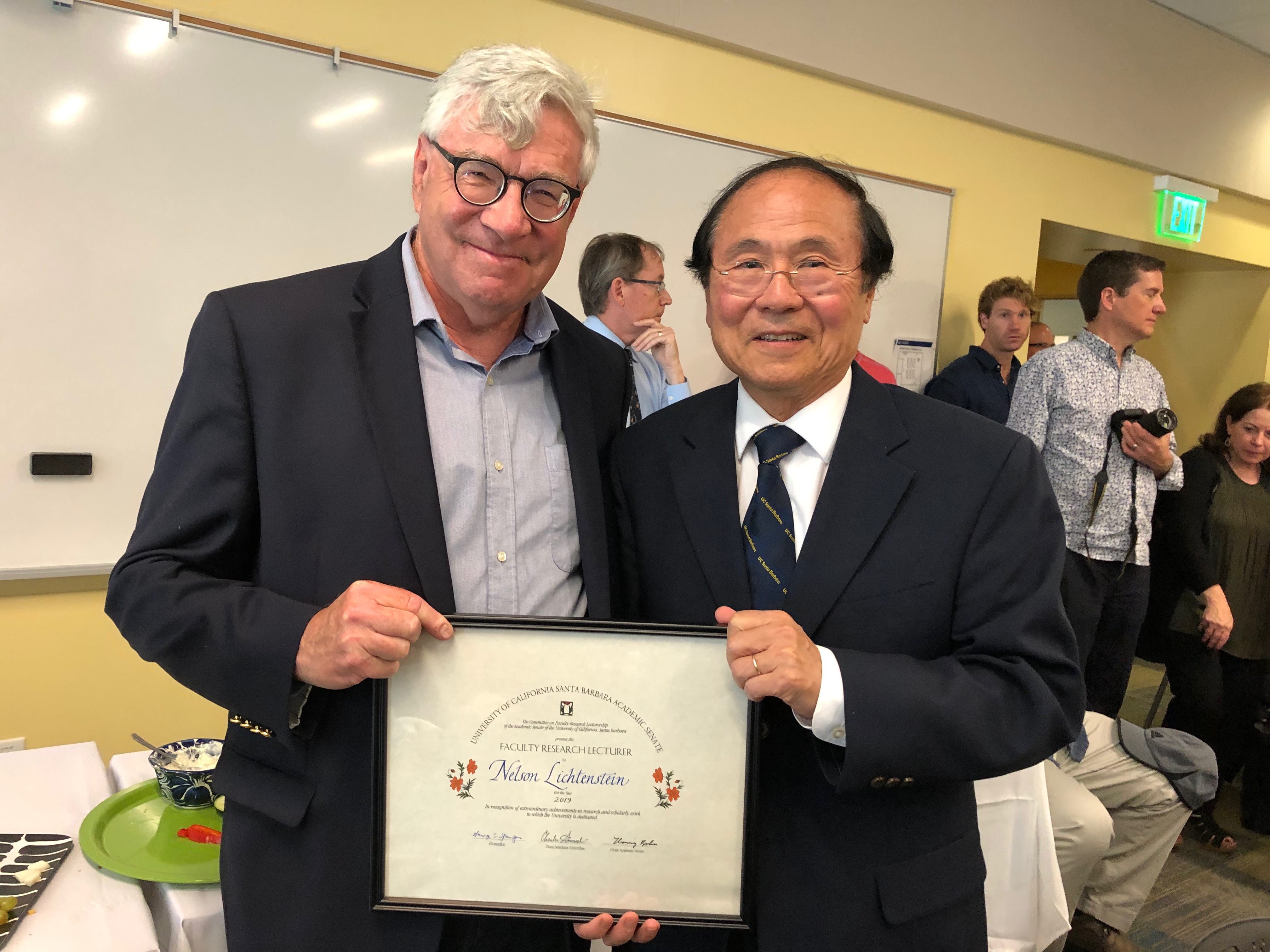 Professor Nelson Lichtenstein Given Top Honor pictured with another person and people mill about in the background