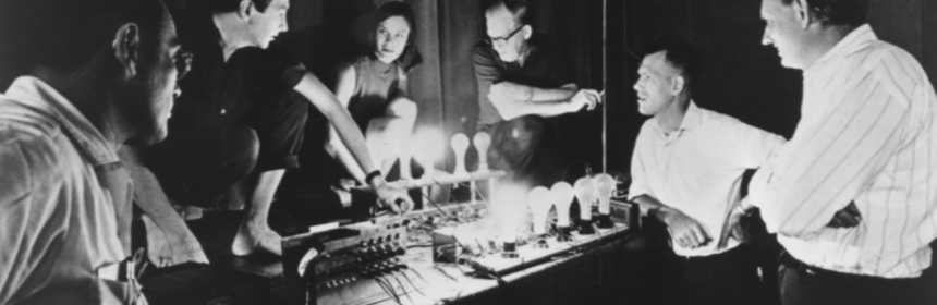 6 adults in front of a system of light bulbs