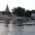 a white building stands across a lake