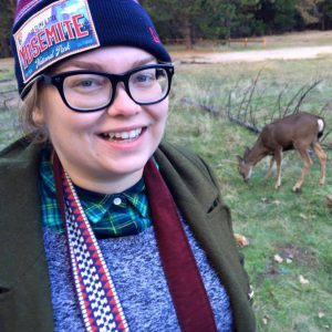 Nicky Rehnberg in a park with a deer in the background