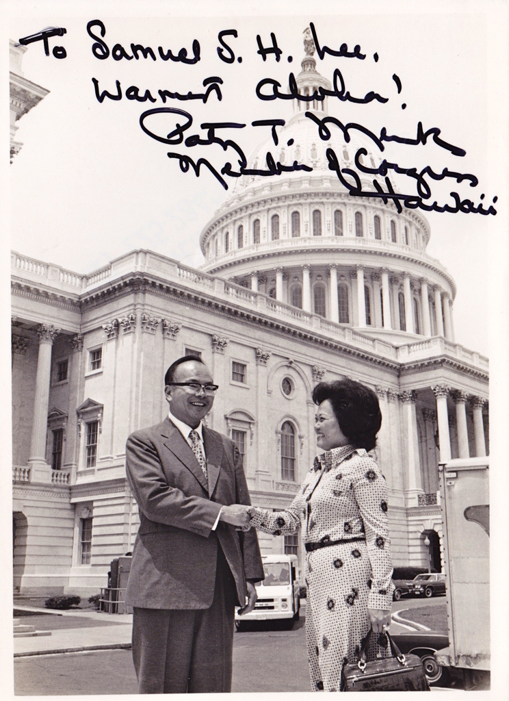 Black and white photo of Sam Lee outside the U.S. capitol shaking hands with Patsy T. Mink. Signed by Mink, to Lee.