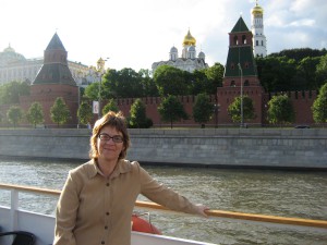 Photo of Adrienne Edgar in front of narrow body of water with building in background